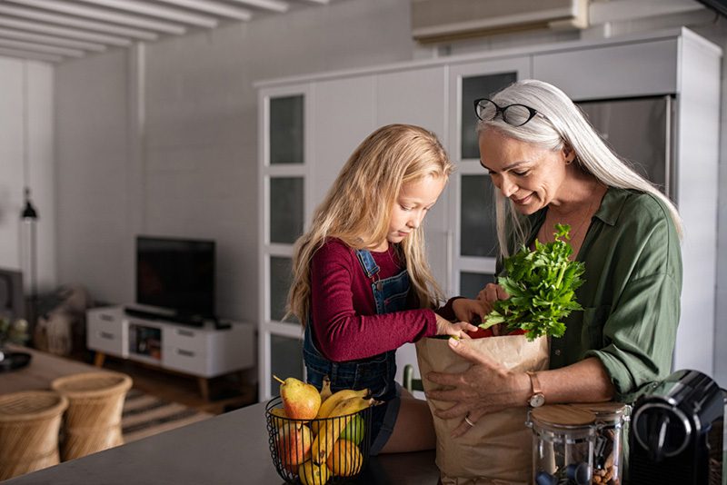 Grandma and girl holding grocery shopping bag